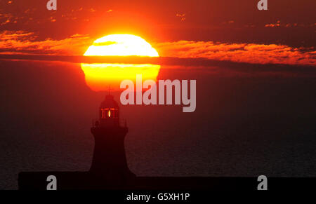 Il sole sorge sul molo South Shields alla foce del fiume Tyne in Tyne e indossare. Foto Stock