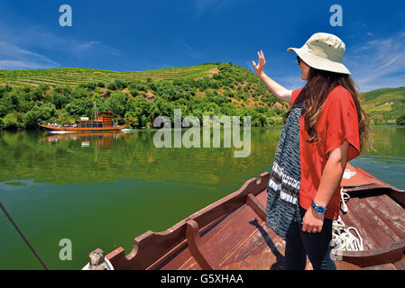 Portogallo: la ragazza con il cappello in tradizionale barca Rabelo saluto altri barca sul fiume Douro Tour Foto Stock