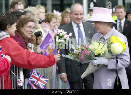 La regina Elisabetta II riceve fiori da wellwishers nella folla durante una passeggiata a Millennium Square, Birmingham. La Regina visitava la zona come parte del suo tour di Golden Jubillee in Gran Bretagna. Foto Stock