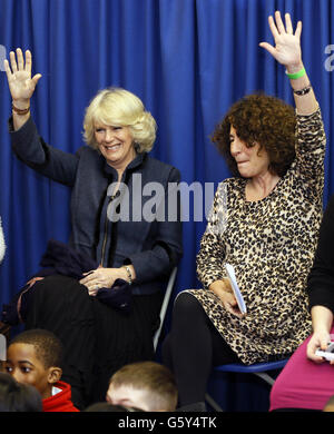 La Duchessa di Cornovaglia alza la mano durante una sessione di narrazione, insieme all'autrice inglese-americana Francesca Simon, autrice dei libri 'Horrid Henry', durante una visita al Discover Children's Story Center di Stratford, Londra. La Duchessa ha incontrato i bambini e il personale scolastico durante la visita per celebrare il decimo anniversario del centro. Foto Stock