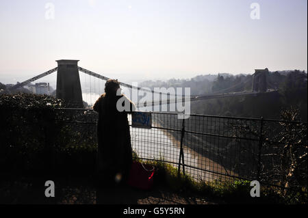Una donna si affaccia sulla gola di Avon a metà mattina con il ponte sospeso Clifton, Bristol, sullo sfondo. Foto Stock