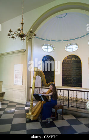 Arpista femmina giocando nella cappella di Geffrye Museum, Kingsland Road, Hoxton, Londra, Inghilterra Foto Stock