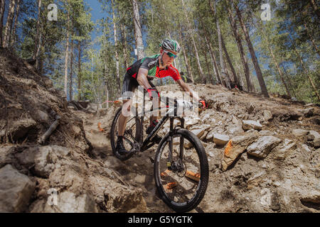 Atleta maschio ciclista va in discesa su pietre Foto Stock