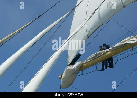 I membri dell'equipaggio della nave a vela russa Mir effettuano riparazioni in corso sulle vele quando arriva al porto di Portsmouth per la fine della corsa delle navi Tall Cutty Sark. *...sessantacinque navi da tutto il mondo convergono sul porto per la festa di quattro giorni che sale la domenica con tutte le navi che entrano nella parata di vela sul Solento. Foto Stock