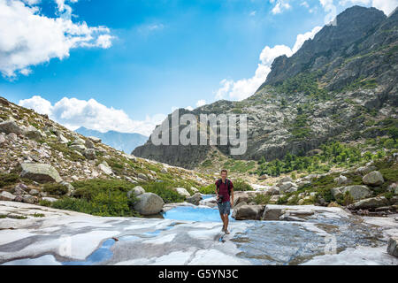 Giovane uomo escursionismo dal fiume Golo in montagna, Parco Naturale della Corsica, Parc naturel régional de Corse, Corsica, Francia Foto Stock