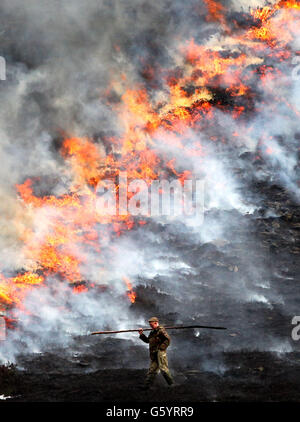 Un guardiano controlla le fiamme mentre la erica è tenuta giovane e ordinata da bruciature controllate o "strofinate" effettuate tra settembre e aprile di ogni anno, sulla Invercauld Estate vicino a Braemar. Foto Stock