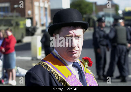 Un orangeman marciò gli ufficiali del servizio di polizia dell'Irlanda del Nord a Carlisle Circus, Belfast, durante una delle tante parate attraverso l'Irlanda del Nord tenute per celebrare il 312esimo anniversario della battaglia del Boyne. Foto Stock