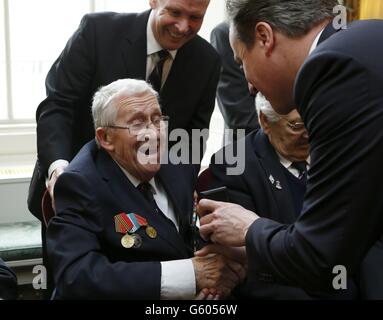 Il primo ministro David Cameron mostra una fotografia di Winston Churchill al veterano della seconda guerra mondiale Ken Whiterod durante la presentazione della medaglia Arctic Star a Downing Street nel centro di Londra. Foto Stock