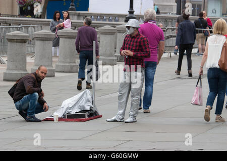 London street artista che esegue, galleggiante e la levitazione trucco, si prende una pausa sigaretta , nella parte anteriore della National Gallery di Londra Foto Stock