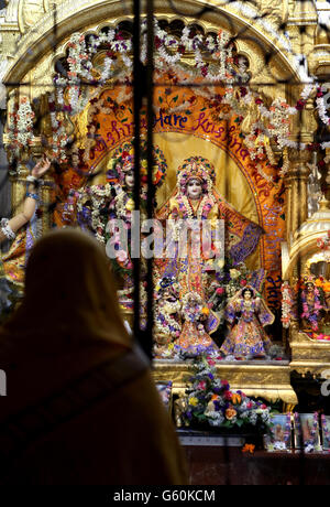 Una donna prega di fronte ad un santuario presso il tempio di Bhaktivedanta Manor Krishna a Hertfordshire nel 40° anniversario del tempio. Foto Stock