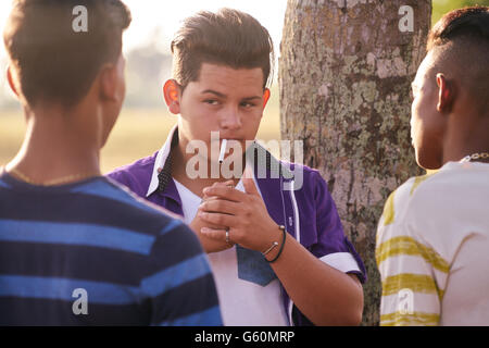 I bambini nel parco il fumo di sigaretta. Concetto di fumatori e questioni sociali con giovani adolescenti Foto Stock