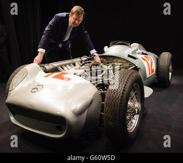 Il presidente della casa d'aste Bonhams Robert Brooks esamina la monoposto Mercedes-Benz W196 Formula 1 da 1954 2.5 litri guidata da Juan Manuel Fangio, in una fotocellula a Bonhams, nel centro di Londra. Foto Stock