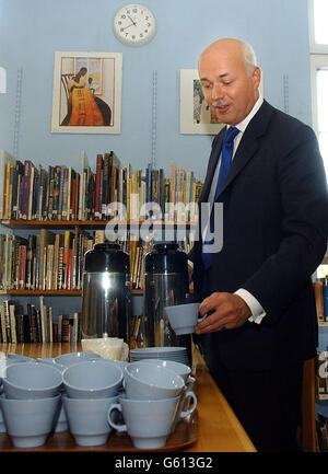 Il leader del partito conservatore Iain Duncan Smith si versa una tazza di caffè durante una visita alla scuola dell'arcivescovo Tennison a Kennington, a sud di Londra. * Duncan Smith ha pagato la visita per lanciare il documento politico - i bambini rimasti dietro - insieme al segretario all'istruzione ombra Damian Green. Il documento ha dichiarato: La sottoesecuzione nell'istruzione delle città interne non è principalmente una questione di finanziamenti, come spesso si afferma, ma di peggioramento della disciplina, carenza di insegnanti, microgestione delle scuole da parte del governo e conseguente povertà di ambizione. Foto Stock