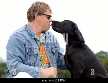 L'attore Martin Clunes, la voce del personaggio del fumetto televisivo 'Merlin', con un cane guida di otto mesi chiamato anche Merlin, che viene addestrato ai cani guida per il centro di formazione Blind Association a Woodford, Essex. Foto Stock