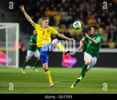 Il svedese Rasmus Elm e Robbie Keane della Repubblica d'Irlanda (a destra) in azione durante la partita di qualificazione della Coppa del mondo FIFA 2014 presso la Friends Arena di Stoccolma, Svezia. Foto Stock