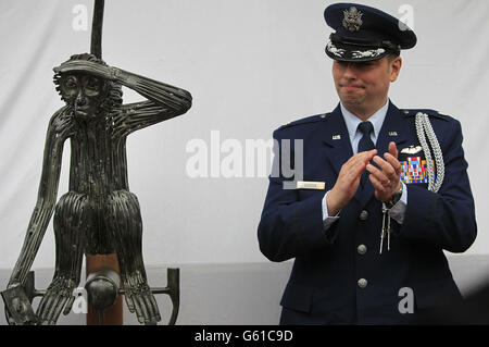 IL tenente-colonnello DELL'aeronautica STATUNITENSE Sean Cossen dell'attache della difesa statunitense nel giardino dell'hotel o'Donovan, applaude alla scoperta di una statua di 'Tojo', una scimmia appartenente ad un equipaggio di un bombardiere dell'aeronautica americana che schiantò sbarcò il loro Boeing B-17 Flying Fortress fuori dalla città di Clonakilty, West Cork Irlanda il 7 aprile 1943. Foto Stock