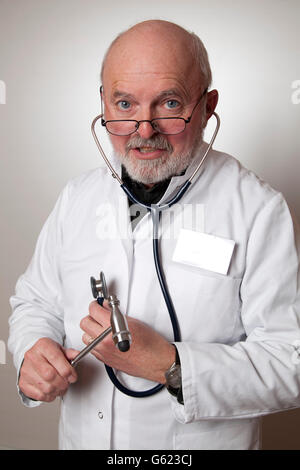 Medico, medico con un martello reflex e uno stetoscopio, indossando il camice bianco Foto Stock