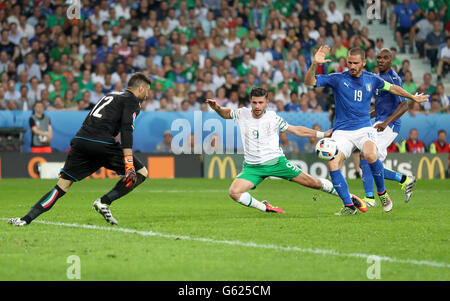 Italia Leonardo Bonucci (destra) e Repubblica di Irlanda Shane lungo (seconda a destra) battaglia per la sfera durante l'Euro 2016, gruppo e corrispondono allo Stade Pierre Mauroy, Lille. Foto Stock