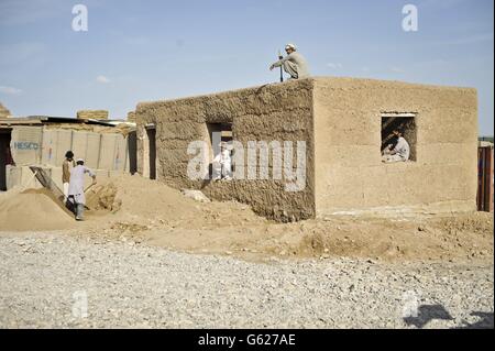 Una visione generale degli operai edili locali afghani che eruttano un edificio alla base di Patrol Clifton, ora rinominato PB Oqab, poiché ospita solo soldati dell'esercito nazionale afghano e viene costruito per soddisfare le loro specifiche esigenze, mentre le forze ISAF iniziano a affidare basi e a lasciare l'Afghanistan nel 2014. Foto Stock