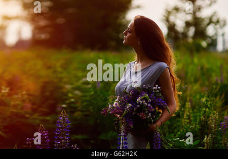 Donna che mantiene un bouquet di lupino azzurro fiori Foto Stock