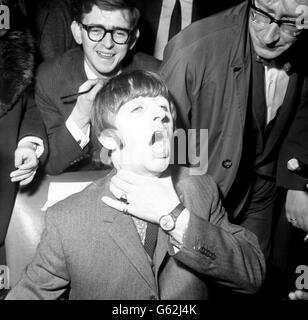 Il batterista dei Beatles Ringo Starr si innamora la gola mentre arriva all'University College Hospital di Londra, dove domani dovrà rimuovere le tonsille. Foto Stock