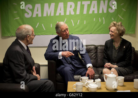 Il principe del Galles, nella sua veste di patrono della carità dei Samaritani, siede con il volontario Allan Toogood (a sinistra) e Felicity Varah Harding, a destra, figlia del fondatore Dr Chad Varah, durante una visita all'ufficio centrale della carità a Londra per celebrare il suo 60° anniversario. Foto Stock