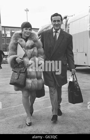 L'attore Patrick MacNee e sua moglie Catherine Woodville in un cappotto di pelliccia 'generoso' all'aeroporto di Heathrow. Foto Stock