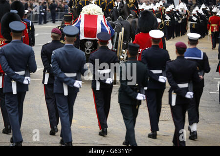 Una bara drappeggiato con bandiera dell'Unione che porta il corpo dell'ex primo ministro Margaret Thatcher viene portata su una carrozza trainata dalla truppa reale del re durante la processione funeraria cerimoniale della baronessa Thatcher, prima dei suoi funerali alla Cattedrale di St Paul, nel centro di Londra. Foto Stock