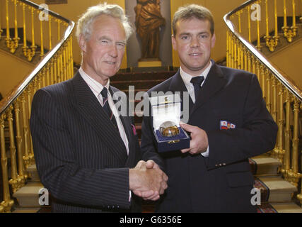 L'ammiraglio della flotta, Sir Julian Oswald, a sinistra, passa il Trofeo Lady Swaythling all'elmsman Nick Beale, della RNLI Porthcawl Inshore Lifeboat, in occasione degli annuali Shipwrecked Fishermen' Royal Benevolent Society Awards e AGM. * ... presso Fishmonger's Hall, nel centro di Londra. Beale, di 34 anni, mostrò un marinaio eccezionale quando salvò un pescatore lavato da un molo in una violenta tempesta di febbraio, con condizioni superiori ai normali limiti operativi della scialuppa di salvataggio "Atlantic 75". Foto Stock