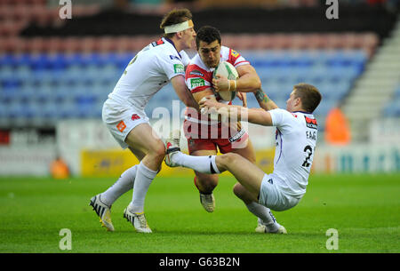 Wigan Warriors ben Flower viene affrontato da Andrew Dixon (a sinistra) e Theo Fages di Salford City Reds durante la partita della Super League al DW Stadium, Wigan. Foto Stock