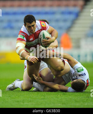 Wigan Warriors ben Flower viene affrontato da Andrew Dixon (a sinistra) e Theo Fages di Salford City Reds durante la partita della Super League al DW Stadium, Wigan. Foto Stock