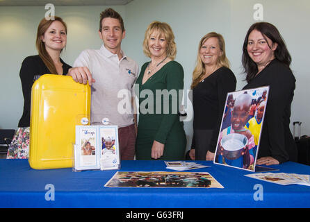 Il personale dell'associazione Just A Drop, da sinistra a destra, Nicola Baskerville, Fiona Jeffrey, Just a Drop Founder, Nicola Swann e Kelly Railton con Chris Cook, solo un ambasciatore della Drop School e un ex nuotatore olimpico presso il terminal delle crociere della città di Southampton prima di salire a bordo della nuova nave della Norwegian Cruise Line, Il Norwegian Breakaway da 146,600 tonnellate. Foto Stock