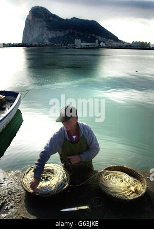 Un pescatore sul lato spagnolo di Gibilterra mette gli uncini nella sua rete con Gibilterra dietro di lui il giorno prima che i Gibraltari prendano parte ad un referendum sulla sovranità congiunta. * la Spagna ha una pretesa su Gibilterra che risale al Trattato di Utrecht del 1713, e negli ultimi anni Londra e Madrid sono diventate vicine a concordare un accordo sul suo futuro, Ma ci si aspetta che la stragrande maggioranza dei 27,000 residenti voterà per bloccare qualsiasi tentativo da parte del governo britannico di dare alla Spagna una parziale sovranità sulla posizione strategicamente importante. Foto Stock