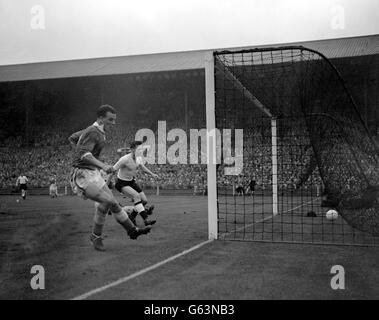 Il centro del Galles, John Charles (a sinistra), spara in una rete vuota per raggiungere il primo obiettivo per il suo paese nella partita di calcio internazionale contro l'Inghilterra all'Empire Stadium Wembley, Londra. Guardare, impotente, è l'Inghilterra sinistra indietro, Roger Byrne. 08/02/04: L'ex attaccante di Leeds, Juventus e Galles John Charles si sta riprendendo nell'ospedale di Milano San Carlo dopo un intervento chirurgico per amputare parte del piede destro, secondo un rapporto del 10 novembre 1954. L'età di 72 anni è stato sottoposto a chirurgia vascolare di emergenza dopo il crollo prima di un aspetto pianificato come un pundit sulla TV italiana prima di questo Foto Stock