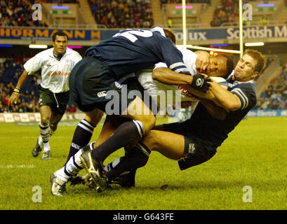 Brendan Laney (12) aiuta a abbattere Epeli Ruivadra (13) con il compagno di squadra Nikki Waker (14) e Atonia Nariva delle Fiji, durante il loro incontro internazionale amichevole a Murrayfield, Edimburgo. Foto Stock