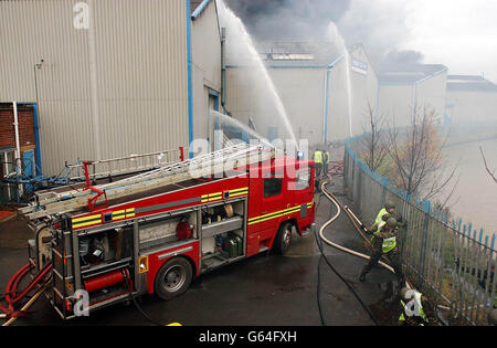 I militari che utilizzano un motore a fuoco rosso affrontano un enorme colpo in una fabbrica di plastica disutilizzata a West Bromwich il primo giorno dello sciopero di otto giorni dei vigili del fuoco nazionali. Anche gli impressionanti vigili del fuoco della vicina base di Willenhall hanno rotto il loro picket per assistere alla scena. Foto Stock