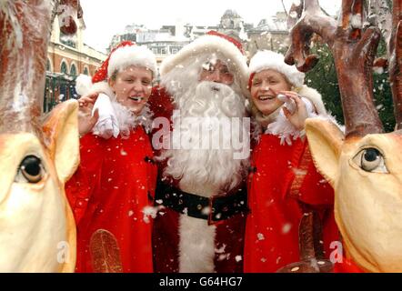 Babbo Natale e i suoi aiutanti Dionne Jones (a destra), 32 da Surrey, e Carolynne Turner, 24, dall'Hampshire durante il lancio dell'unica grotta di Babbo Natale all'aperto di Londra nel mercato di Covent Garden nel centro di Londra. Foto Stock