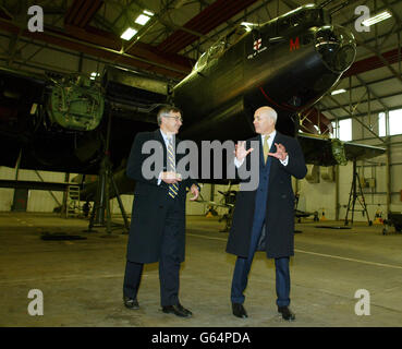 Il leader del Partito conservatore Iain Duncan Smith cammina sotto un bombardiere Lancaster con il ministro della difesa ombra Gerald Howarth al museo di volo commemorativo della Battaglia di Gran Bretagna a RAF Coningsby, Lincolnshire. Foto Stock