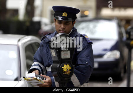 Un operaio controlla i parchimetri a Soho, nel centro di Londra. 17/01/04:gli operai del traffico sono la professione più odiata del Regno Unito, secondo un'indagine pubblicata. Hanno superato la lista, appena battendo i rimbalzi, gli agenti della proprietà e i corrieri del motociclo. Foto Stock