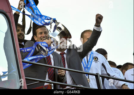 Justin Edinburgh, il manager dell'AFC della contea di Newport, solleva il trofeo mentre la sua squadra torna al Ground Rodney Parade dopo la parata di vittoria del club attraverso Newport. Foto Stock