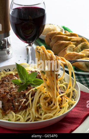 Italiano tradizionale piatto di spaghetti alla bolognese/bolognese servita con pane all'Aglio/Baguette e parmigiano grattugiato. Foto Stock