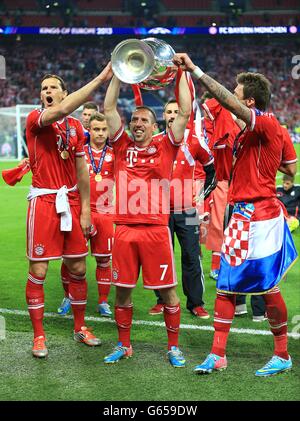 (Da sinistra a destra) Daniel van Buyten, Franck Ribery e Mario Mandzukic di Monaco celebrano con il trofeo Champions League in campo Foto Stock