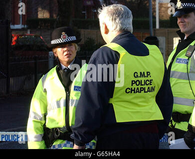 Il grande cappellano di polizia di Manchester parla con gli ufficiali di polizia all'ingresso di Crumpsall Lane a Manchester, dove il conestabile detective Stephen Oake, 40, è stato pugnalato a morte durante un raid Martedì su sospetti terroristici. * ... legato alla scoperta a Londra del micidiale ricino veleno. Il signor Oake, padre di tre di Poynton a Cheshire, che ha servito presso la filiale speciale delle forze, è morto al North Manchester General Hospital dopo aver ricevuto cure di emergenza sulla scena. Foto Stock