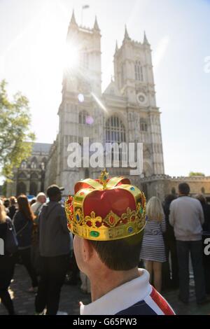 Un uomo che indossa una corona aspetta fuori dall'Abbazia di Westminster, nel centro di Londra, prima di un servizio di celebrazione per celebrare il 60° anniversario dell'incoronazione della Regina Elisabetta II. Foto Stock