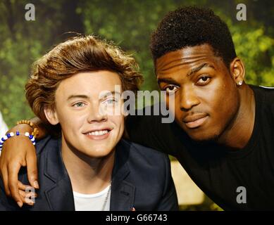 Derry Mensah un membro del X-Factor TV show contestants The Risk boy-band, pone con ex contestant il modello di cera di Harry Styles da una direzione a Madame Tussauds nel centro di Londra. Foto Stock