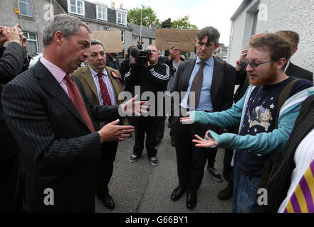 Nigel Farage, leader dell'UKIP, parla con i manifestanti durante le campagne per le elezioni di Aberdeen Donside con il candidato del partito otto Inglis (non raffigurato) al di fuori dello Staging Post pub Aberdeen. Foto Stock