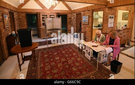 Funzionari attendere per gli elettori all'interno di una stazione di polling utilizzata nell'UE referendum in una guest house allegato in Dogmersfield, Hampshire. Foto Stock