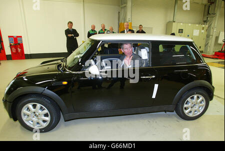 Il Prince of Wales guida una Mini fuori dalla linea di produzione presso lo stabilimento BMW di Cowley nell'Oxfordshire. Il Principe ha incontrato alcuni dei 4,500 collaboratori che hanno aiutato a produrre il nuovo Mini che è stato lanciato nel luglio 2001. Foto Stock