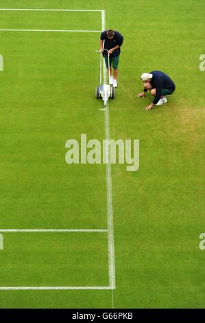 Le linee sono dipinte sul campo durante il giorno uno dei Campionati di Wimbledon all'All England Lawn Tennis and Croquet Club, Wimbledon. Foto Stock