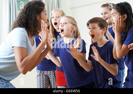 Gruppo di bambini con insegnante godendo di dramma insieme di classe Foto Stock